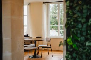 einen Tisch und Stühle in einem Zimmer mit Fenster in der Unterkunft La Casa Pampa — Comfort, Style & Modernity in Falaise