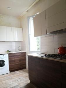 a kitchen with a stove and a washing machine at FRESH Hotel Kobuleti in K'obulet'i