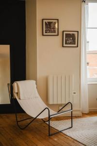 einen weißen Stuhl in einem Zimmer mit Fenster in der Unterkunft La Casa Pampa — Comfort, Style & Modernity in Falaise