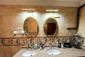 two sinks in a bathroom with two mirrors at Halic Apart Hotel in Yalova