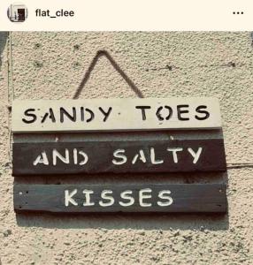 a sign that says sandy toes and salty kisses at Sea view Apartment Sandy Toes and Salty Kisses Sleeps upto 4 in Cleethorpes