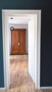 Sains-RichaumontにあるAppartement complet chic et cosyのウッドフロアの客室への開閉式ドア