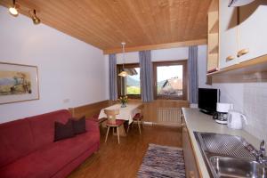 sala de estar con sofá rojo y mesa en Apartments Gasserhof, en Lagundo