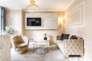 ein Wohnzimmer mit einem Sofa und einem TV in der Unterkunft Casa Gauda — Jacuzzi, relaxation & serenity in Falaise