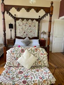een slaapkamer met een bed met een houten hoofdeinde bij Le Château Giat in Giat