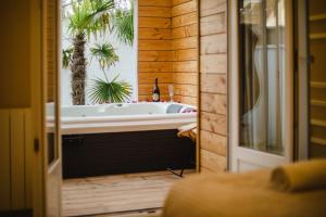 ein Bad mit einer Badewanne in einem Zimmer in der Unterkunft Casa Gauda — Jacuzzi, relaxation & serenity in Falaise