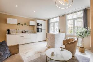 cocina y sala de estar con mesa y sillas en Casa Gauda — Jacuzzi, relaxation & serenity en Falaise