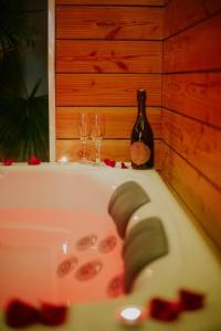 eine Badewanne mit zwei Weingläsern und einer Flasche in der Unterkunft Casa Gauda — Jacuzzi, relaxation & serenity in Falaise