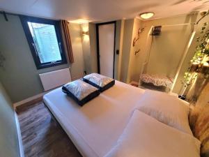 ein großes weißes Bett in einem Zimmer mit Fenster in der Unterkunft Verblijf midden in de natuur in de Jagershut! in Hattemerbroek