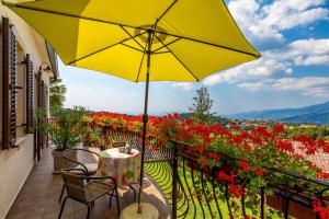 een gele paraplu op een balkon met bloemen bij Apartment Srok, Romantic in Kastav