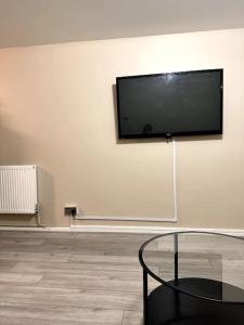 a flat screen tv on a white wall with a table at Apartment in Greenwich in London