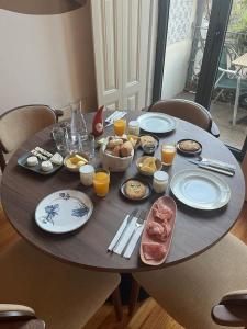 - une table en bois avec des aliments pour le petit-déjeuner et des boissons dans l'établissement Vila Camélia, à Porto