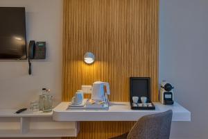 a desk in a hotel room with a phone on it at Cardoner Hotel és Konferenciaközpont in Dobogoko