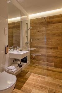 ein Badezimmer mit Waschbecken und Dusche in der Unterkunft Cardoner Hotel és Konferenciaközpont in Dobogókő