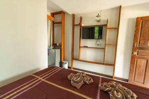1 dormitorio con 1 cama con sábanas marrones y puerta en BangPo Resort en Ban Bang Po