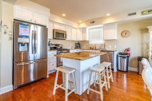 a kitchen with white cabinets and a stainless steel refrigerator at Central Ave Getaway with Elevator in Ocean City