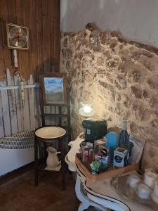 a bathroom with a table with food and a stone wall at Ca la Serreta in Cretas