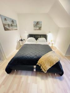 a bedroom with a large black bed with two pillows at aday - Randers Elegant and Trendy Apartment in Randers