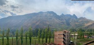 a view of a mountain range with trees and a building at SAMAY Casa familiar en el valle sagrado in Calca