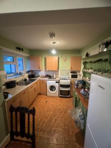 a kitchen with a refrigerator and a stove top oven at Highgate Hill Room! in London
