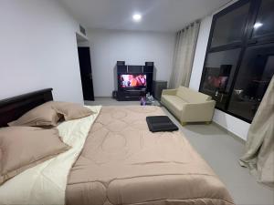 a bedroom with a large bed and a television at Heart of Abu Dhabi - Adorable Master Room in Abu Dhabi