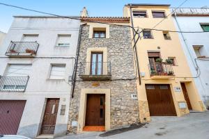 - un vieux bâtiment en pierre avec une porte et des fenêtres dans l'établissement Ca la Llum, à Tivissa