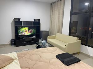 a living room with a couch and a tv at Heart of Abu Dhabi - Adorable Master Room in Abu Dhabi