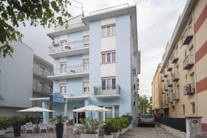 un edificio de apartamentos con fachada azul y blanca en Hotel Eliseo en Rímini