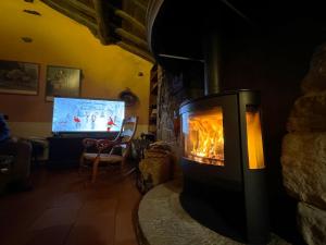 einen Kamin im Wohnzimmer mit TV in der Unterkunft Villa El Molino Blanco in Molinos de Razón