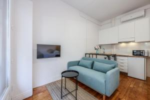 un salon avec une chaise bleue et une cuisine dans l'établissement Victoria Apartments, à Madrid