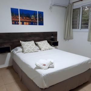 1 dormitorio con 1 cama grande con sábanas blancas en VILLA CUBA en Villa Rumipal