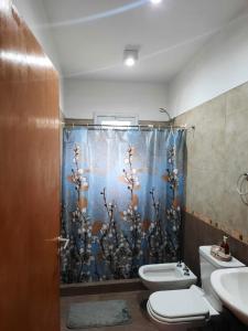 y baño con cortina de ducha y aseo. en VILLA CUBA en Villa Rumipal