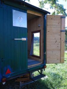 a green shipping container house with a door open at Schäferwagen Hotzenplotz 