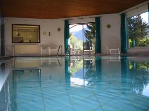 a swimming pool with blue water in a house at Appartements Amrusch in Sankt Jakob im Rosental