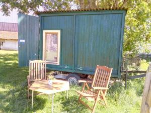 two chairs and a table in front of a tiny house at Schäferwagen Hotzenplotz 