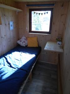 Kleines Zimmer mit einem Bett und einem Fenster in der Unterkunft Schäferwagen Hotzenplotz 