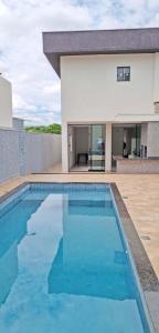 una piscina frente a una casa en Casa aconchegante c/ piscina e área de lazer, en Maringá