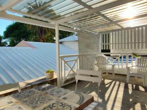 a patio with a white pergola and a table and chairs at Mermaid Cove in Blue Bay