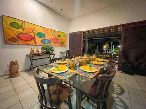 uma sala de jantar com uma mesa com pratos amarelos em RESERVA DO PAIVA - A MELHOR CASA PARA TEMPORADA em Recife