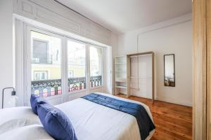 - une chambre avec un lit et une grande fenêtre dans l'établissement Victoria Apartments, à Madrid