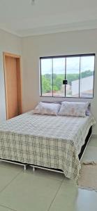 1 dormitorio con 1 cama grande y ventana grande en Casa aconchegante c/ piscina e área de lazer, en Maringá
