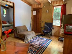 a living room with a room with a bed and a table at Cabaña entre Boldos in Villarrica
