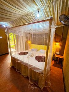 ein Schlafzimmer mit einem Himmelbett in einem Zimmer in der Unterkunft Wild Safari Clay House in Udawalawe