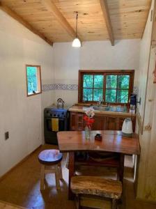 a kitchen with a wooden table and a stove at Cabaña entre Boldos in Villarrica