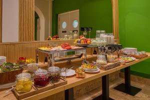 ein Buffet mit Speisen auf einem Tisch in der Unterkunft Cardoner Hotel és Konferenciaközpont in Dobogókő