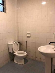 a bathroom with a toilet and a sink at Dahlia Homestay (Wi-Fi & Netflix) in Miri