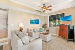 a living room with a couch and a ceiling fan at Makena Surf G-201 - End Unit, Panoramic Views, AC! in Wailea