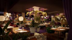 un ristorante con tavoli, sedie e piante di The Home Hotel Zürich - a member of DESIGN HOTELS a Zurigo