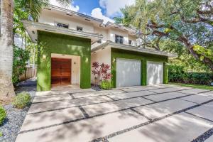 ein Haus mit einer grünen Wand und einer Auffahrt in der Unterkunft Villa Roxi in Miami