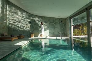 a woman is standing next to a swimming pool at Pullman Mazagan Royal Golf & Spa in El Jadida